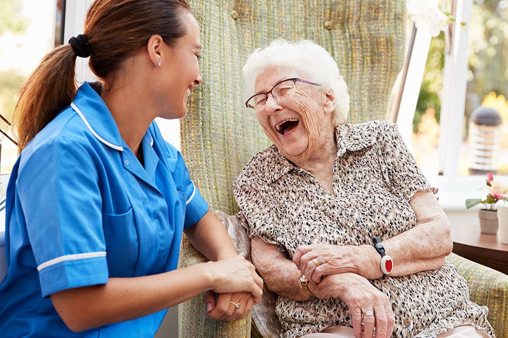 Elderly women laughing with nurse