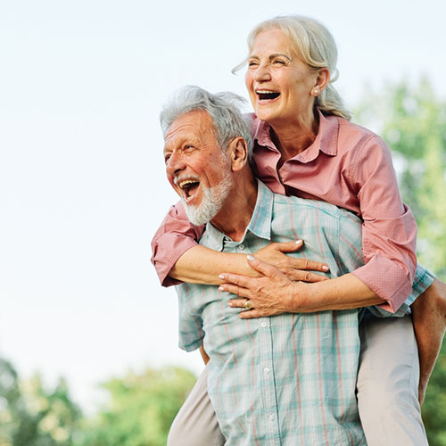 An elderly man carrying her partner on back