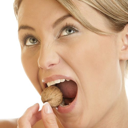 Women trying to break walnut 