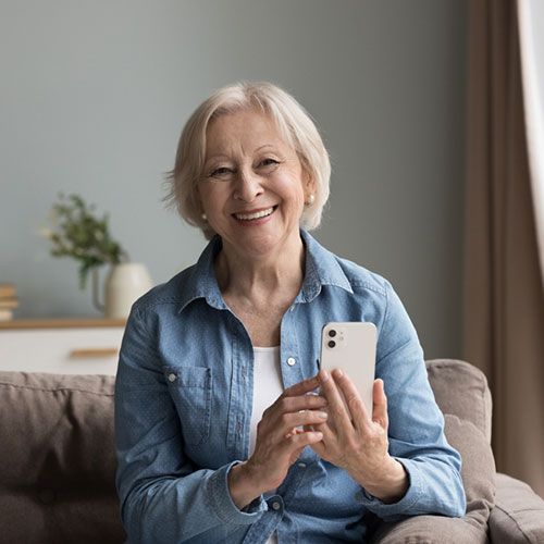 An elderly women holding a phone