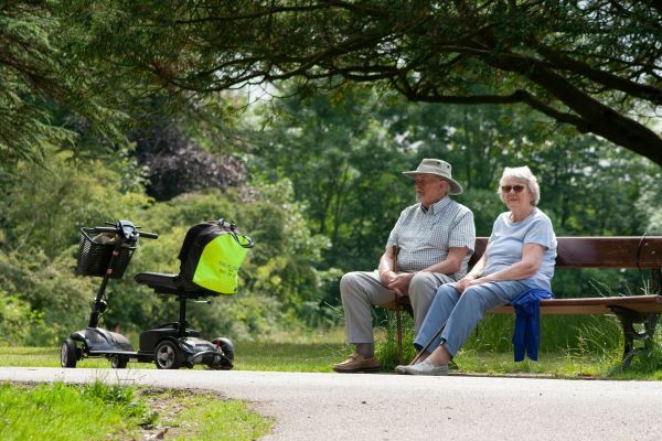 Senior couple at the park with their Mobility Scooter